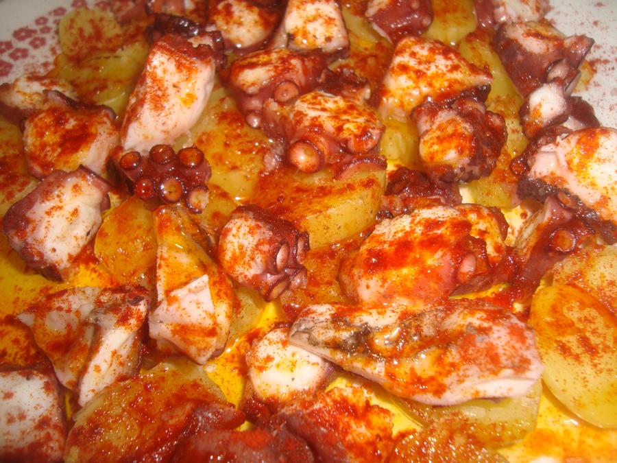 Scheiben von Pulpo a la Gallega mit Paprikapulver auf Kartoffeln