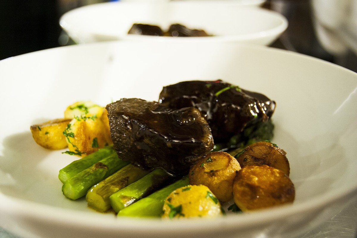 Dunkel geschmorte Rinder-Short-Ribs auf einem Teller mit Gemüsebeilage