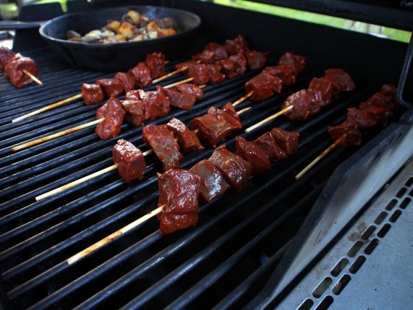 Gegrillte Anticuchos-Spieße aus Rinderherz auf einem Teller