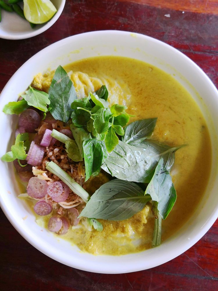 Schale Num Banh Chok mit grüner Fischsauce und frischen Kräutern