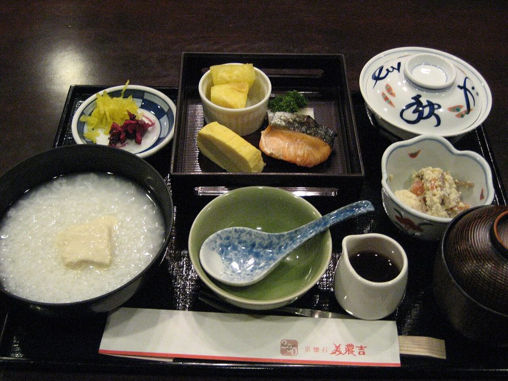Schale mit cremigem weißem Reisbrei (Okayu) in einem japanischen Frühstücks-Tablett
