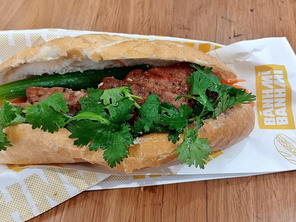 Bánh mì mit gegrilltem Schweinefleisch, Koriander und Karotten in Papier