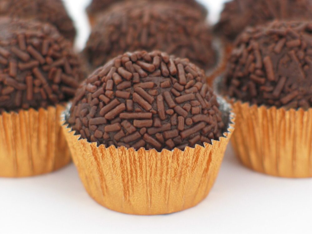 Brigadeiros mit Schokostreuseln in goldenen Papierförmchen