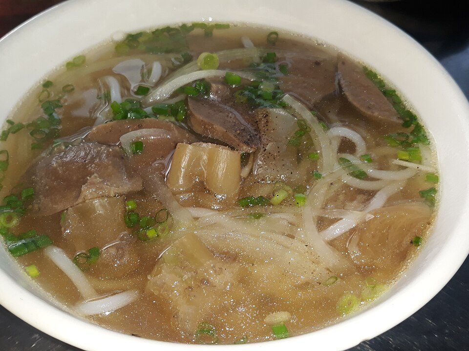 Schale Bún bò Huế mit dicken Reisnudeln, Rindfleisch und Fleischbällchen in Brühe