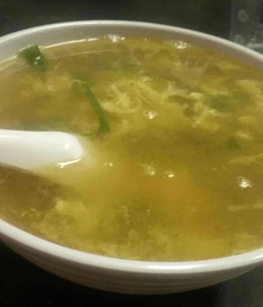 Schale gelbliche Eierflockensuppe mit Frühlingszwiebel