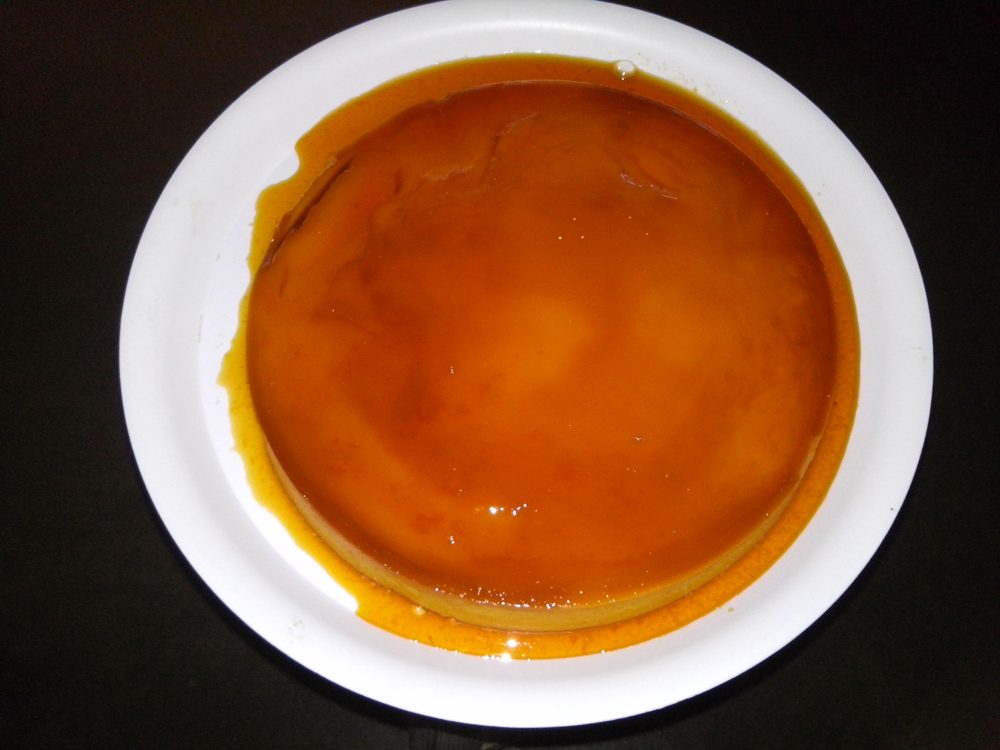 Gestürzter Flan mit Karamell auf einem weißen Teller