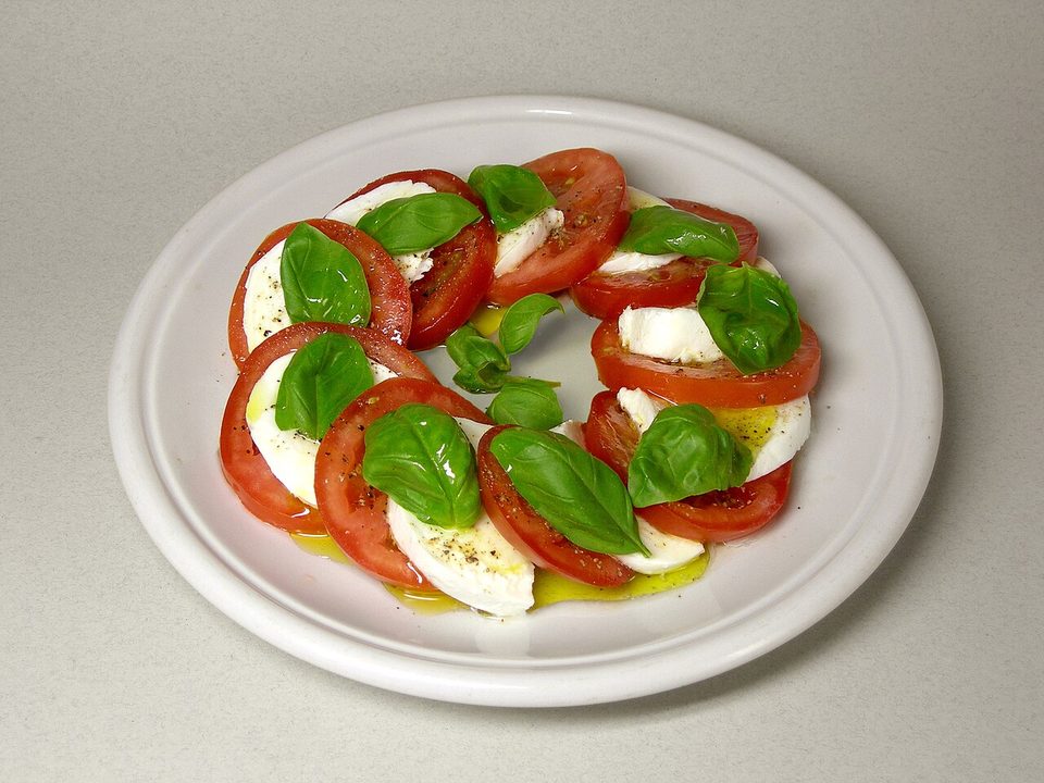 Insalata caprese mit Tomaten-, Mozzarellascheiben und Basilikum