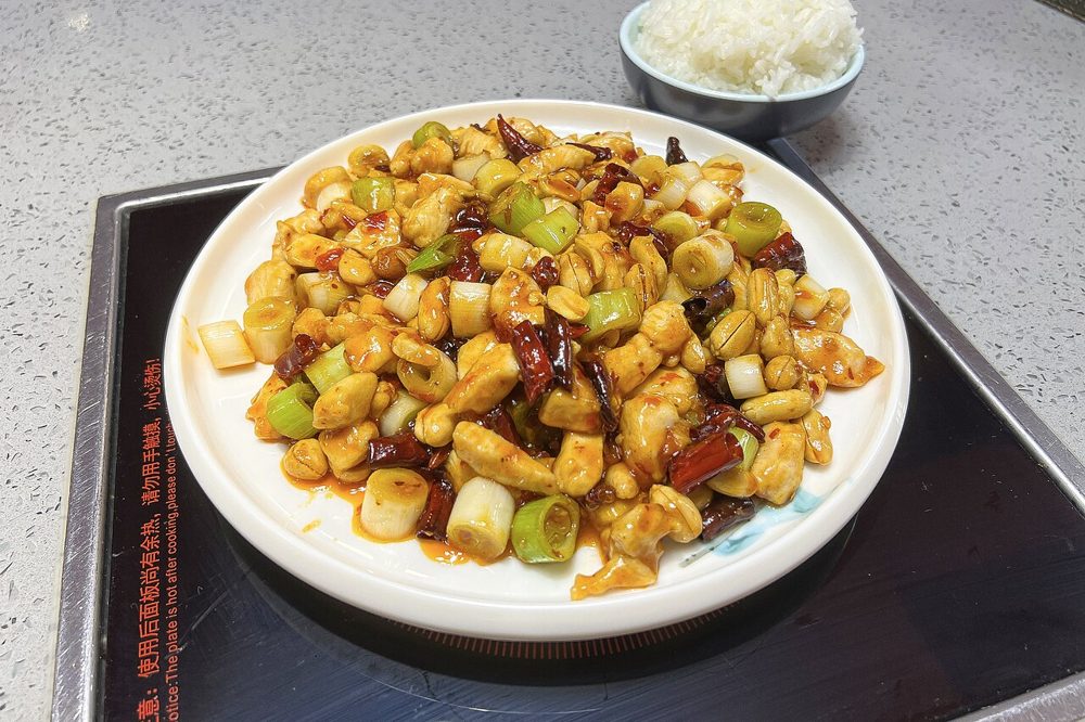 Teller Kung-Pao-Hähnchen mit Erdnüssen, Frühlingszwiebel und Chilis