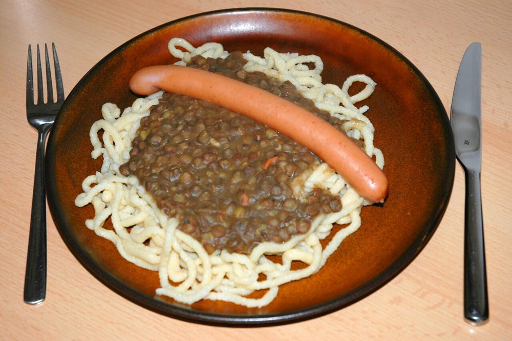 Linsen mit Spätzle und Würstchen auf einem Teller