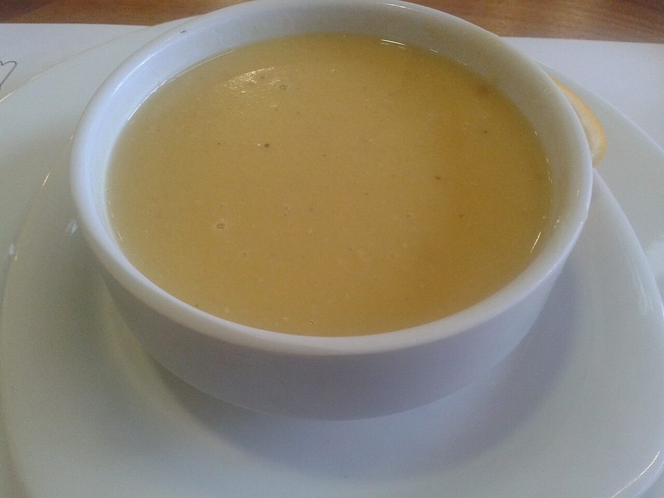 Orangefarbene Linsensuppe mit rotem Gewürzöl und Zitronenspalte