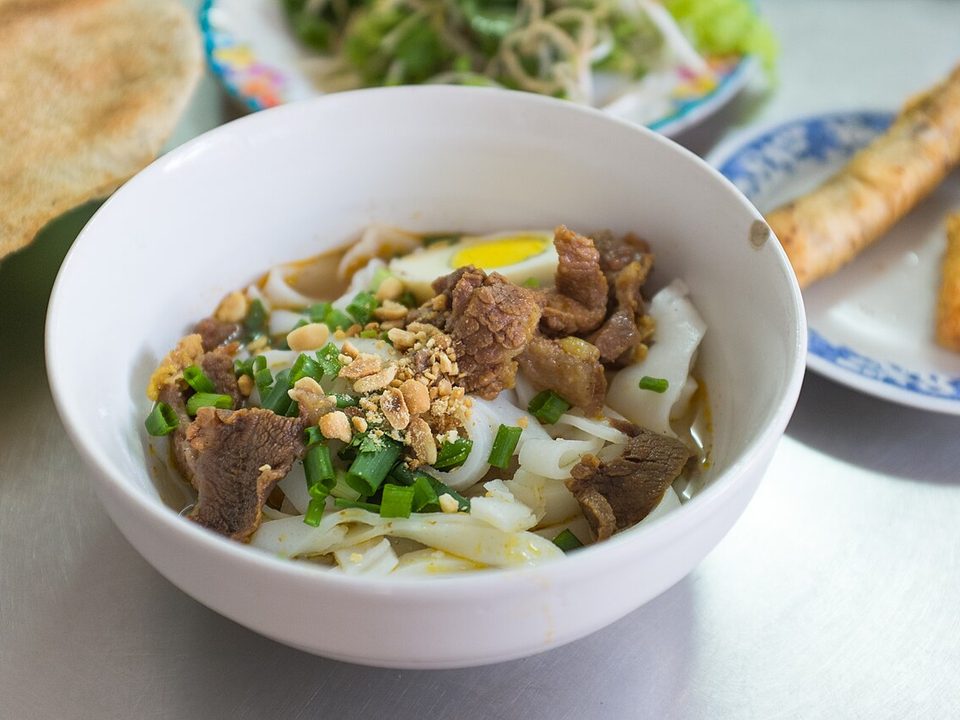 Schale Mì Quảng mit breiten Nudeln, Fleisch, Erdnüssen und Frühlingszwiebeln