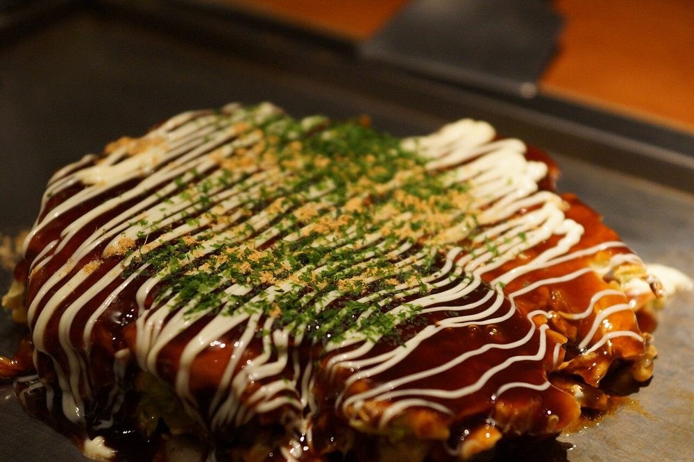 Okonomiyaki mit Sauce, Mayonnaise und Aonori