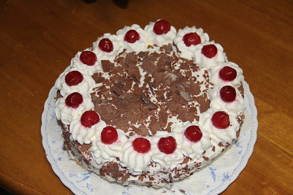Ganze Schwarzwälder Kirschtorte mit Sahnetupfen und Kirschen