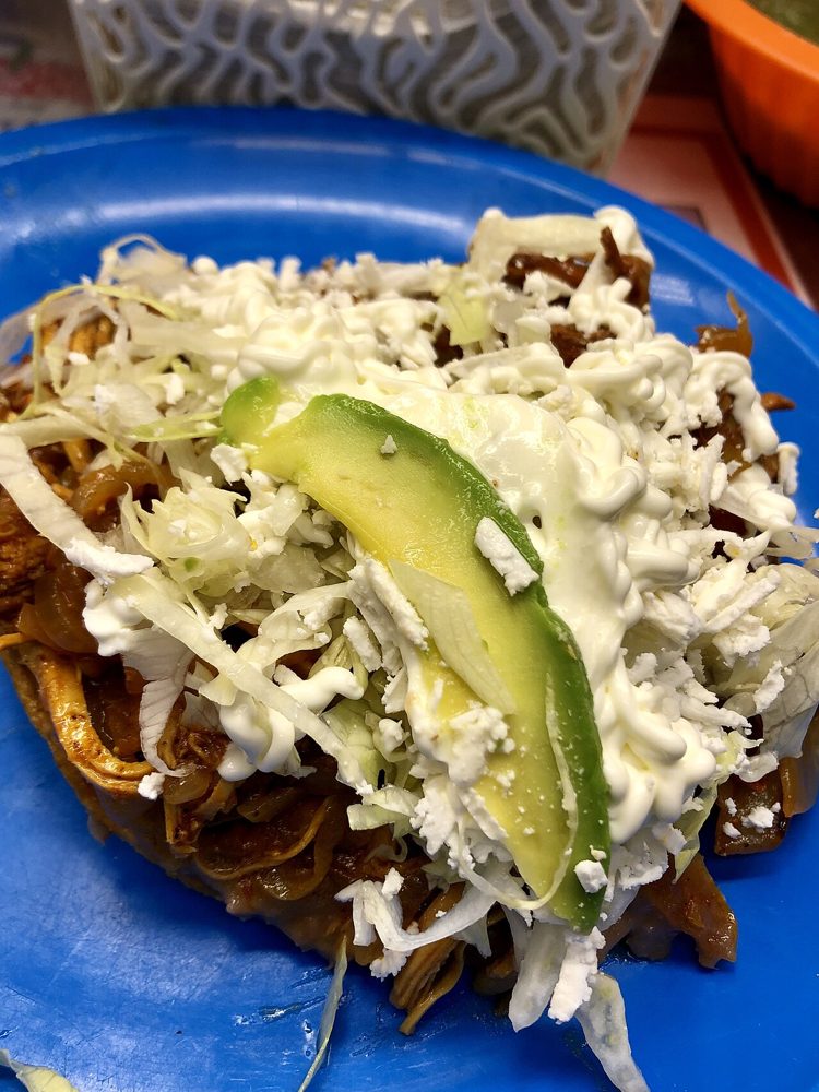 Tostada mit Tinga de pollo, Salat, Käse und Avocado